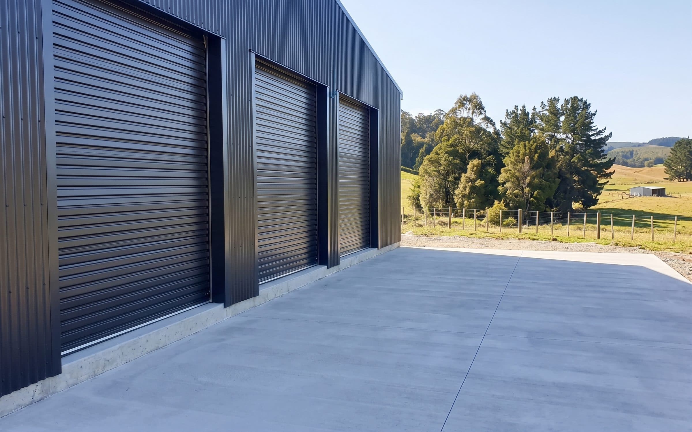 Light commercial roller doors on a steel-clad rural shed