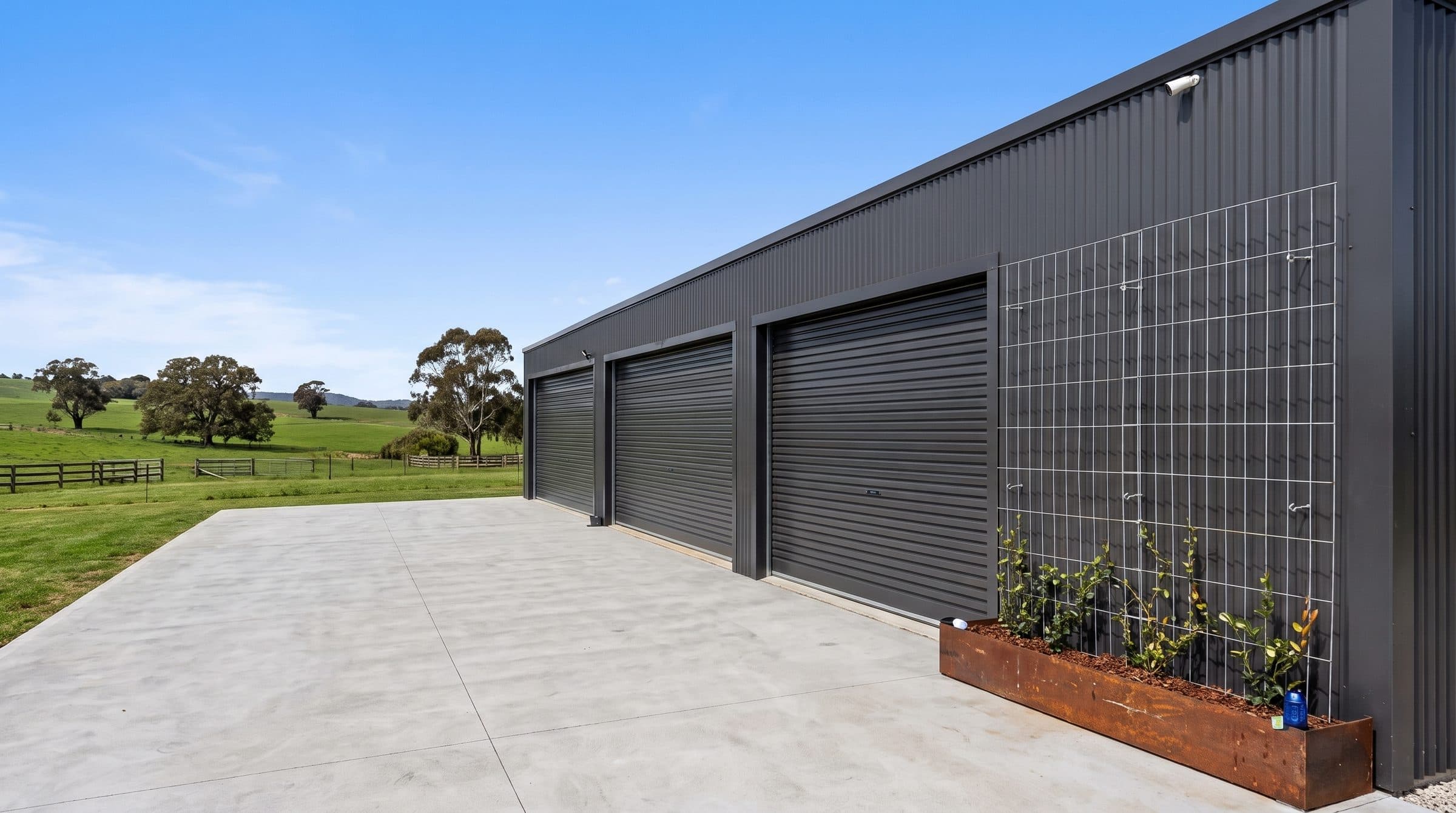 A run of light commercial roller doors on a long steel-clad building