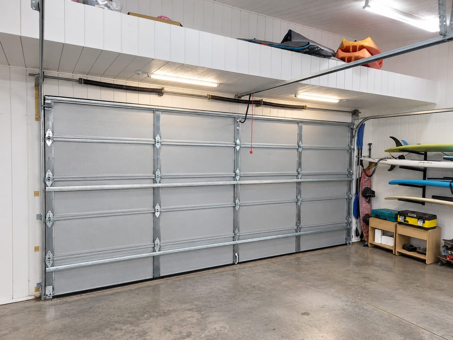 The inside of an uninsulated sectional garage door, bare steel panels and bracing