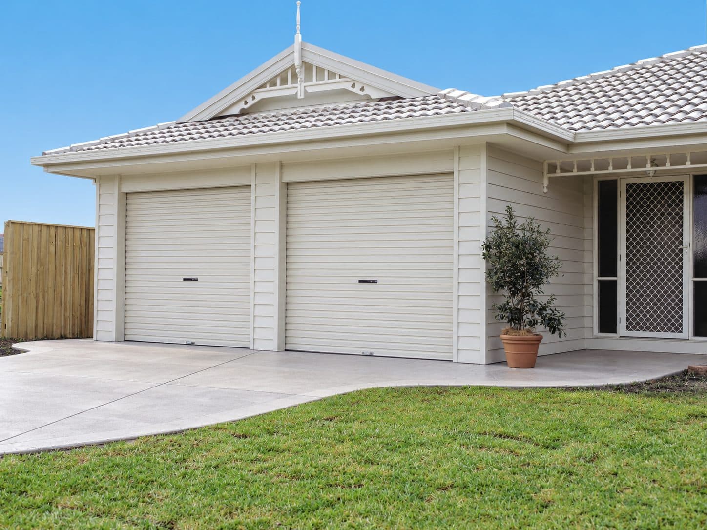 A pair of white residential roller doors on a Rodney home
