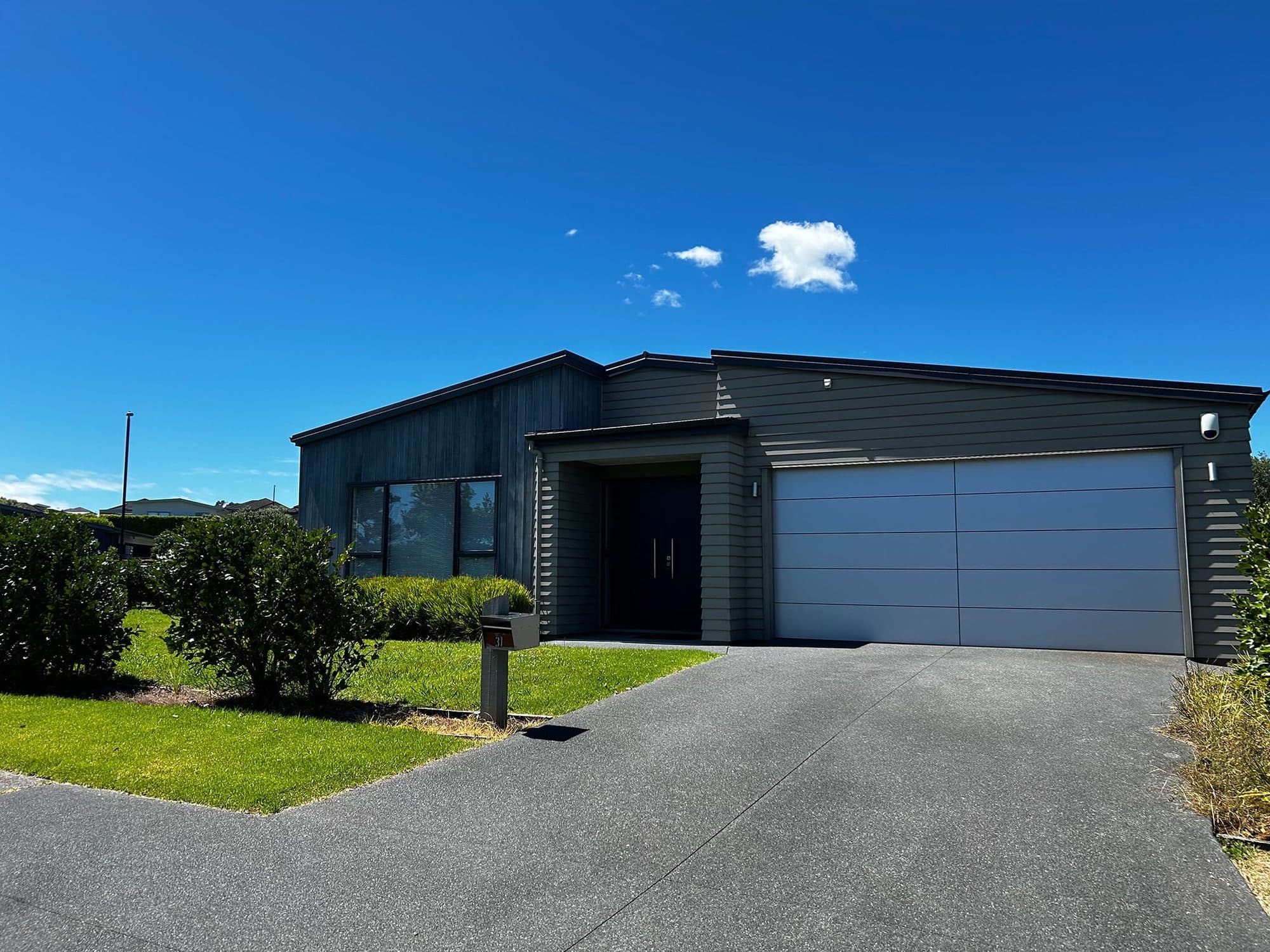 An aluminium garage door on a modern coastal home