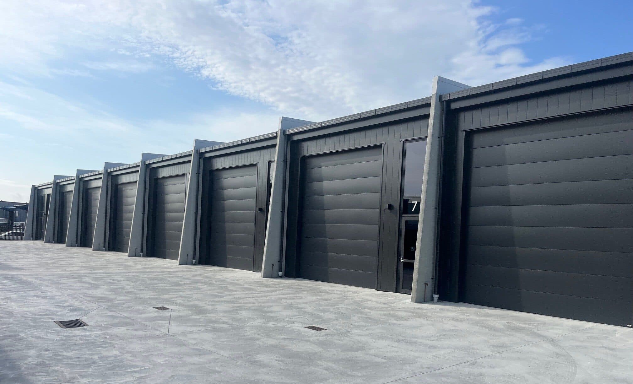A run of dark roller doors on a Silverdale building